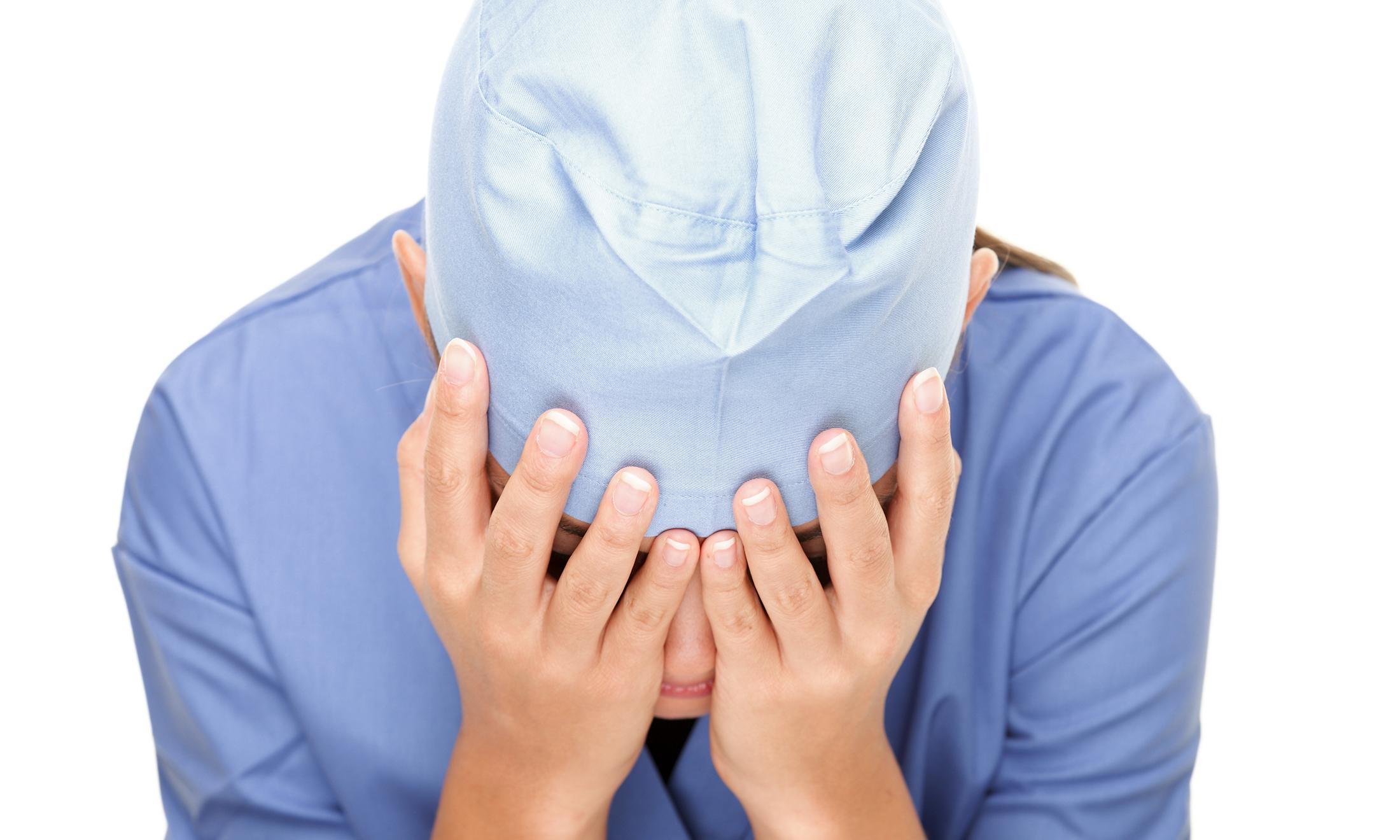 An image of a person in scrubs who appears to be upset.