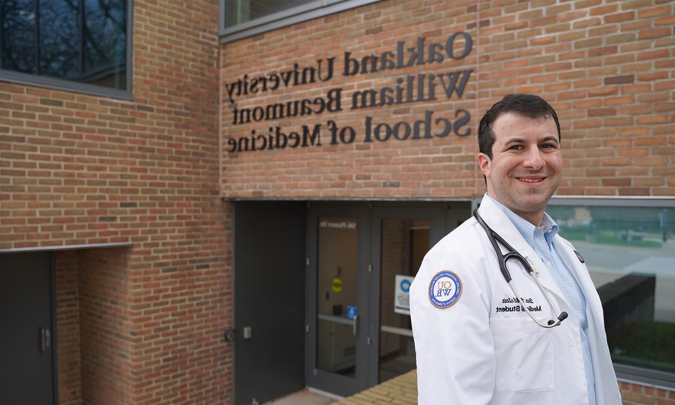 An image of OUWB student Benjamin Goldstein in front of the school's sign